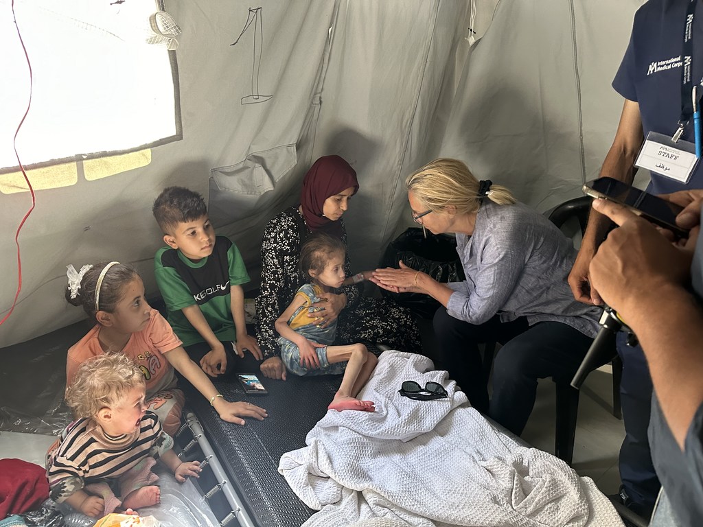Sigrid Kaag rencontre un enfant malnutri et sa famille dans un hôpital de campagne de l'International Medical Corps, à Gaza.