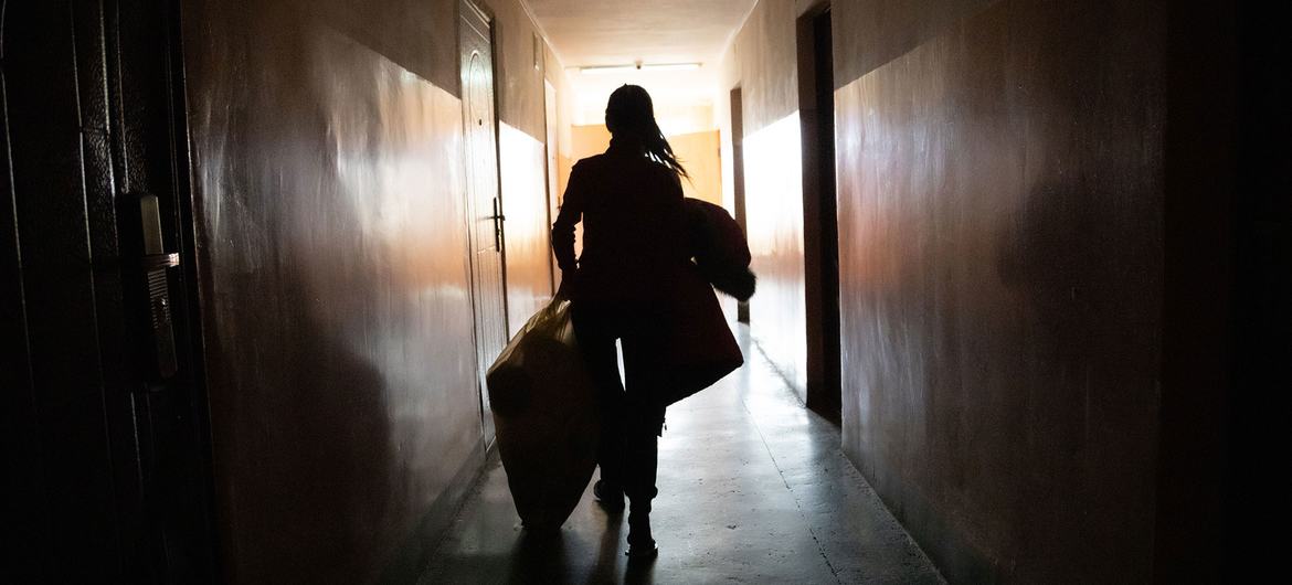 Uma mulher deslocada de Kramatorsk, na região de Donetsk, no leste da Ucrânia, seleciona roupas quentes para sua família em seu alojamento temporário em Mukachevo, oeste da Ucrânia.