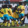 A seleção feminina juvenil do Brasil comemora com um abraço coletivo em campo durante uma partida.