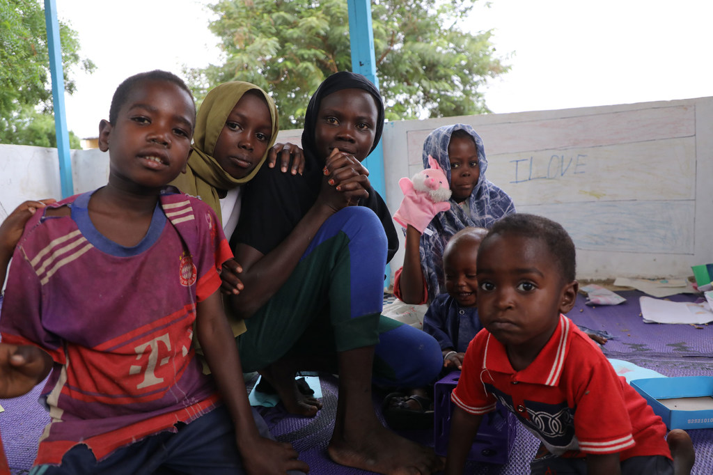 Watoto wameketi pamoja katika kituo cha muda ambacho ni rafiki kwa watoto, iliyoko katika eneo la wakimbizi huko Adré, mashariki mwa Chad, wakati wa ziara ya Mkurugenzi Mtendaji wa UNICEF Catherine Russell.
