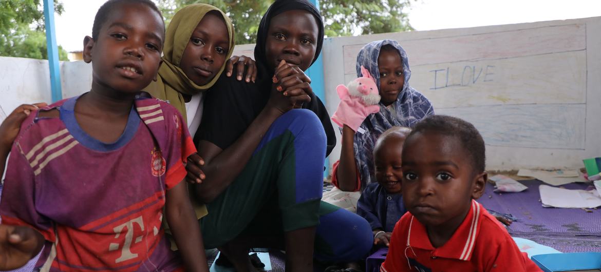 يجلس أطفال اللاجئين السودانيين معاً في مساحة متنقلة صديقة للأطفال في موقع أدري للاجئين في شرق تشاد، بدعم من UNICEF.