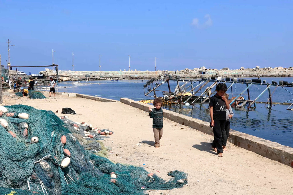 أطفال يمشون حفاة على ميناء غزة المدمر أطفال يمشون حفاة على ميناء غزة المدمر