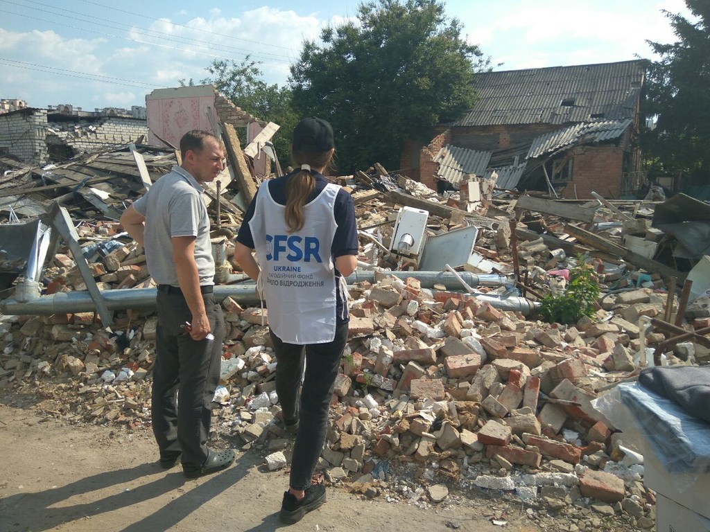 Представитель МОМ и волонтер осматривают обломки разрушенного здания в Харькове, Украина.