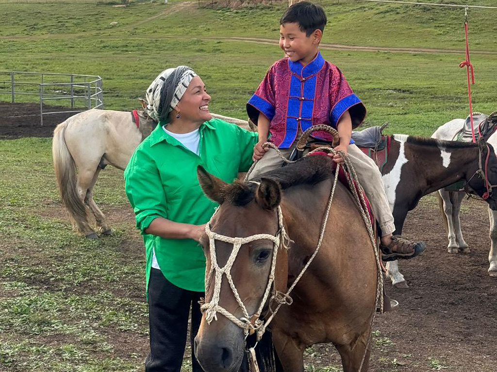 The UN Deputy Secretary-General Amina Mohammed interacts with a child in Mongolia.