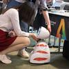 Женщина приветствует робота на прошлогоднем саммите «ИИ во благо» в Женеве.