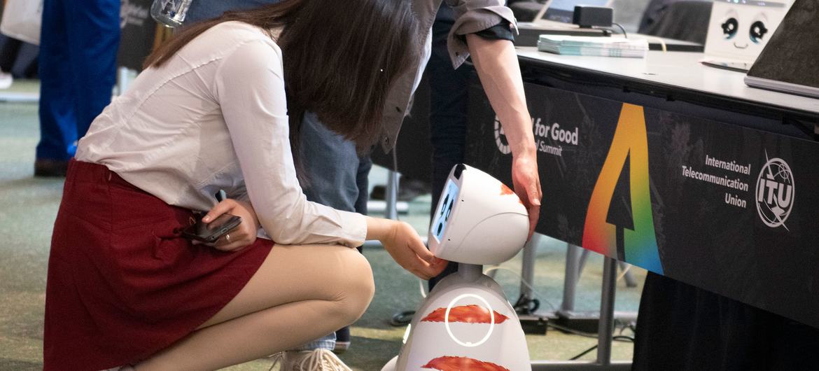 在日内瓦举行的2024年人工智能全球峰会上，一名女士向机器人打招呼。