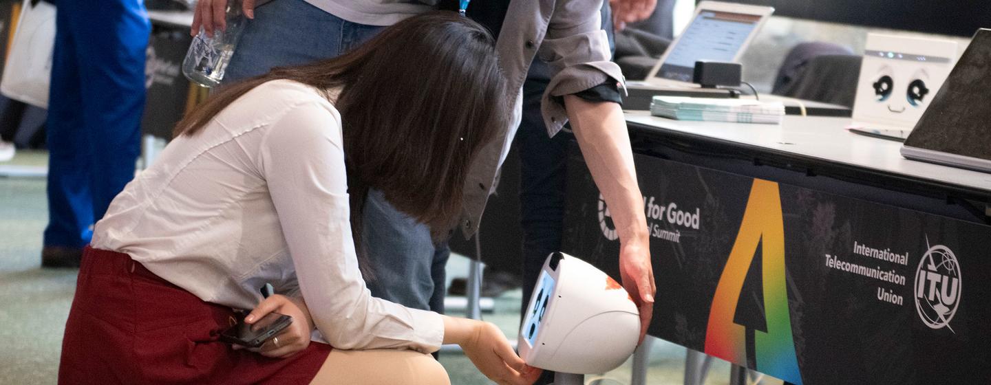 A woman greets a robot at the AI ​​for Good 2024 Global Summit in Geneva.