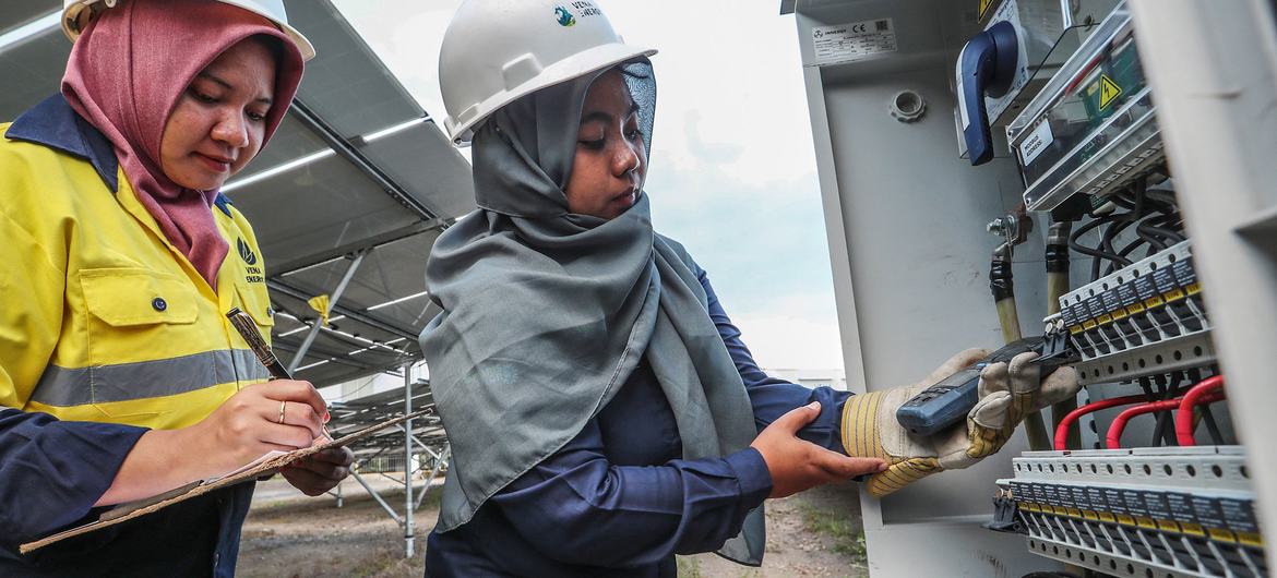 سيدتان تعملان في محطة لتوليد الطاقة الشمسية في إندونيسيا