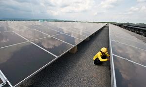 A technician works at a solar panel plant in Thailand.
