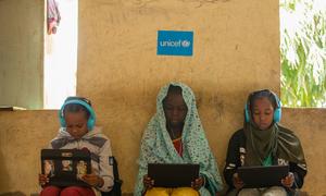 Girls who fled their homes in war-torn Sudan take part in a digital learning session in Kassala state.