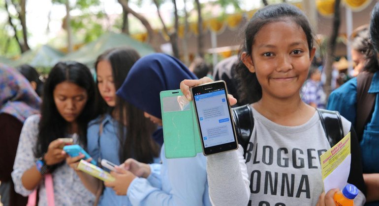 Adolescentes de Indonesia usando sus teléfonos móviles.