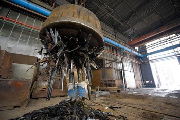 一台大型工业磁铁将工厂内的一堆小型武器和轻型武器吸了起来。