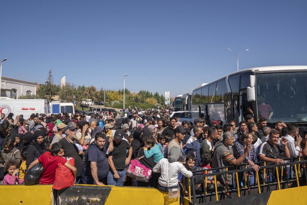 Syrian and Lebanese families, who fled the escalating violence in Lebanon arrive in Syria.