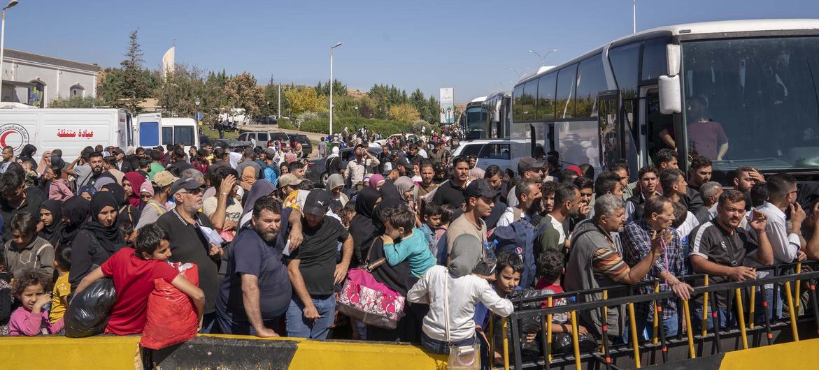 Des Syriens et des Libanais ayant fui l'escalade de la violence au Liban arrivent en Syrie.