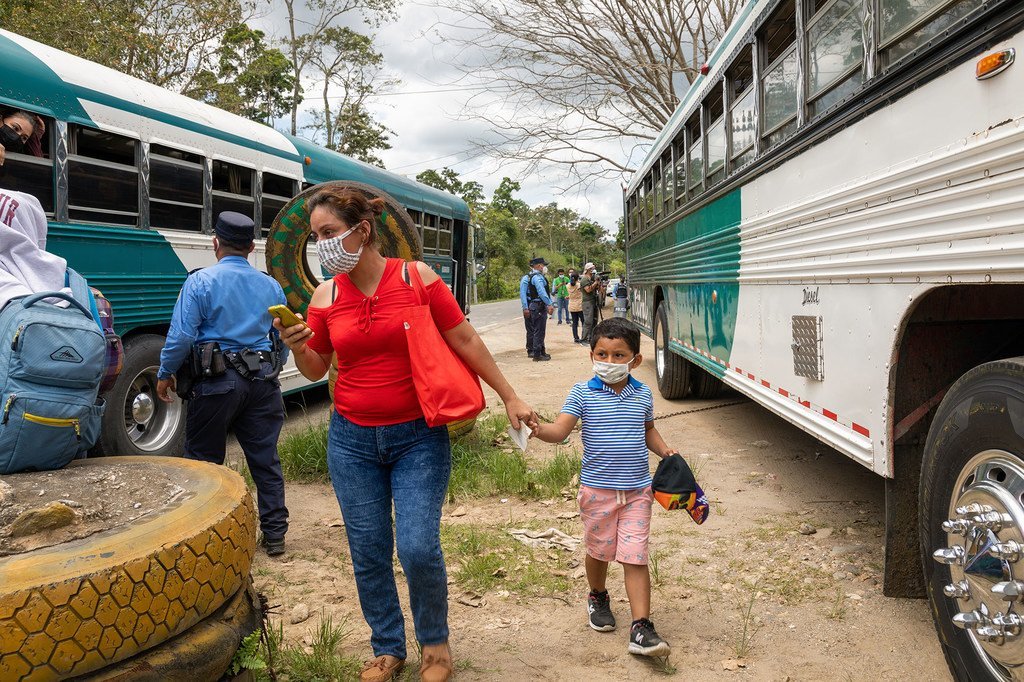 Agentes de policía revisan la documentación de los autobuses que transportan migrantes en un puesto de control fronterizo en Centroamérica.