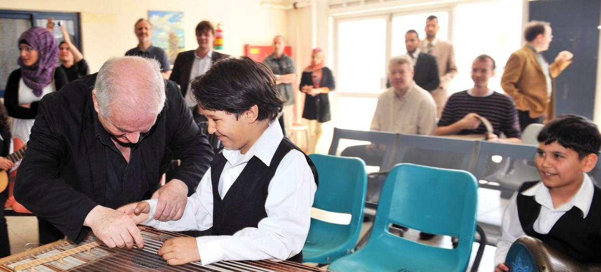 أرشيف 2011: المايسترو العالمي دانييل بارينبويم (يسار) مع أحد الموسيقيين الصغار بعد أن عزفوا مقطوعاتهم احتفالا بزيارة بارينبويم الأولى لقطاع غزة. أسس بارينبويم (الأرجنتيني -الإسرائيلي) أوركسترا الديوان الشرقي الغربي مع صديقه المفكر والكاتب الفلسطيني إدوار…