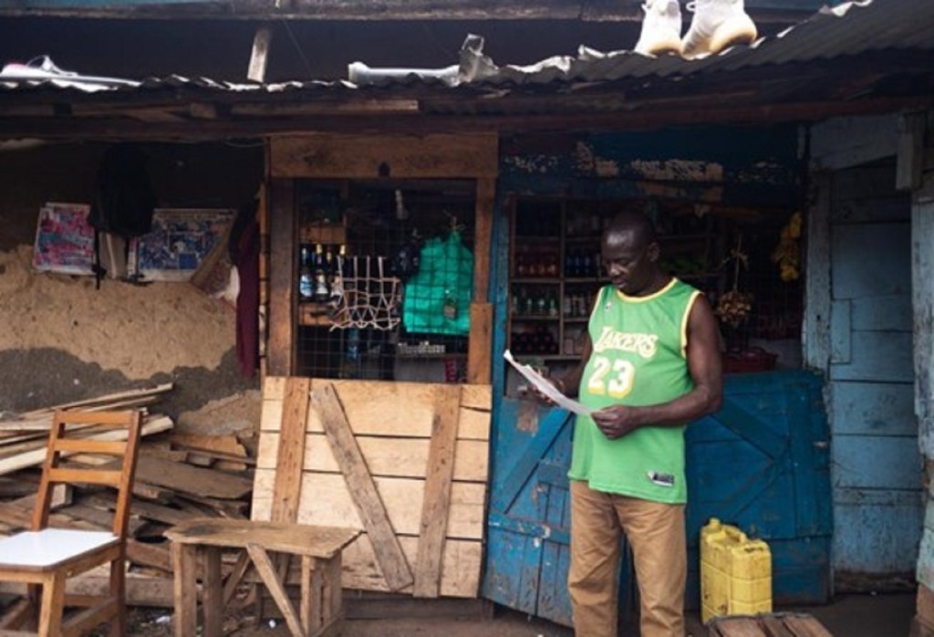 Arinaitwe na timu yake wanasimama kwenye duka la Charles Atoba kutoa elimu kuhusu Ebola