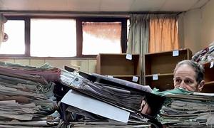 The head of the International, Impartial and Independent Mechanism Investigating Serious Crimes in Syria (IIIM), Robert Petit, looks at documents at a court house in Damascus, Syria.
