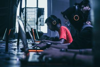 Gamers play on laptops alongside each other.