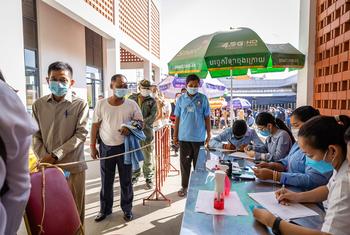 कम्बोडिया की राजधानी नामपेन्ह में, लोग कोविड-19 की वैक्सीन का टीका लगवाने के लिए, एक अस्पताल के बाहर पंक्ति में.