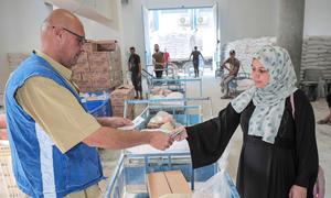 A Palestine refugee receives food assistance packages at the UNRWA Jabalia distribution centre in Gaza.