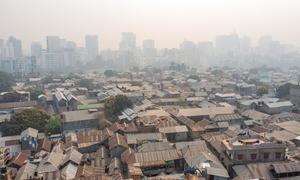 Slums in Dhaka, the capital city of Bangladesh, with high rises behind.