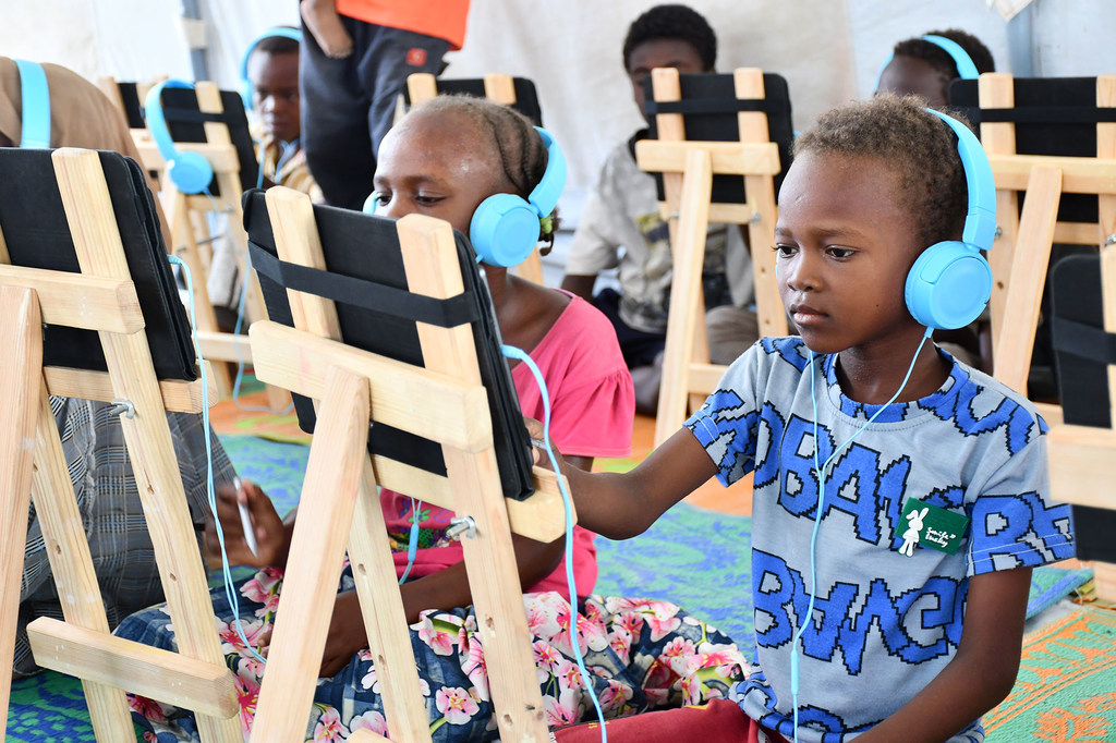 因冲突而流离失所的儿童在苏丹港的安全学习空间进行数字学习。