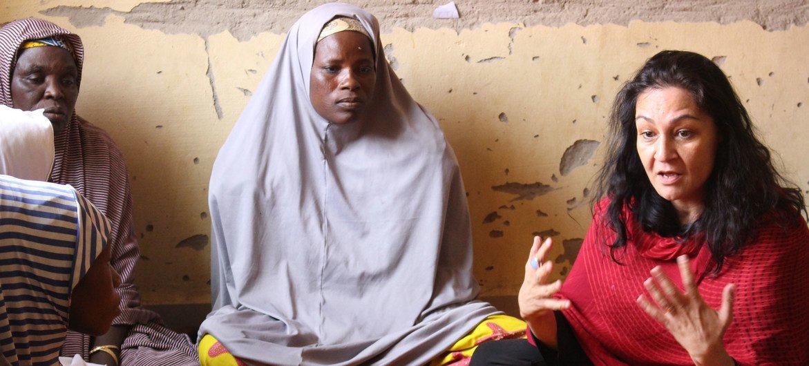 在尼日利亚东北部的迈杜古里，盖拉尼（右）与一处境内流离失所者营地的妇女会面。