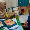 Conselheira mostra a uma mulher opções de controle de natalidade no centro de saúde em South Sulawesi, na Indonésia