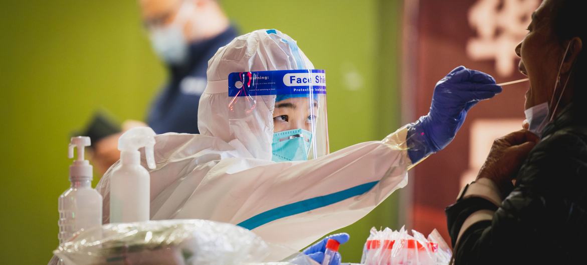 Una trabajadora de salud hace la prueba del COVID-19 una mujer en Shenzhen, China. (Archivo)