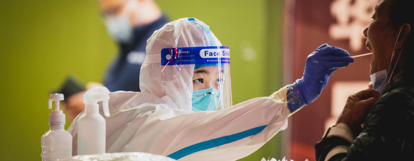 Un agent de santé effectue un test de dépistage du COVID-19 sur une femme à Shenzhen, en Chine.