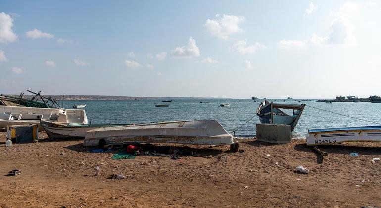 Migrants sleep underneath a boat on the beach in Obock, Djibouti.