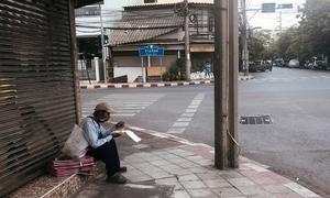 An informal sector worker eats by the roadside in Bangkok.