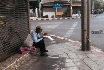 An informal sector worker eats by the roadside in Bangkok.