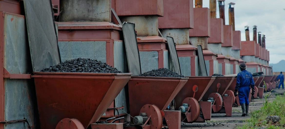 Workers at a tobacco factory in Malawi fill processing machinery with coal. (file)