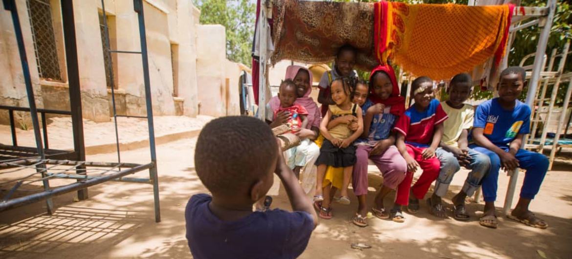 نقل مکانی پر مجبور سوڈانی بچے اپنے عارضی ٹھکانے کے گرد اکٹھے ہیں۔