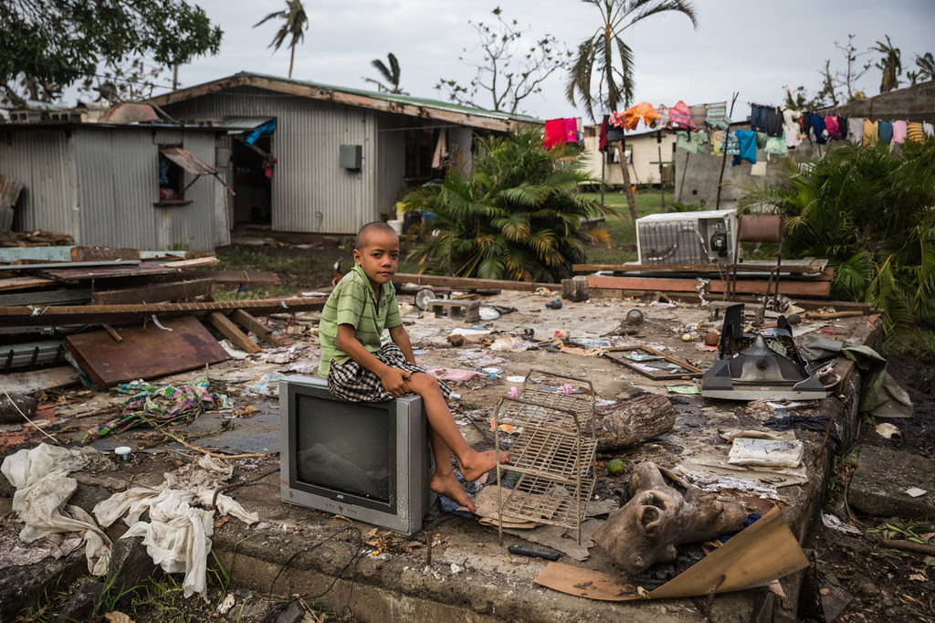 Uraia, de 7 años, sentado en un televisor sobre los restos de su casa, que fue destruida por el ciclón Winston en Fiyi en 2016.