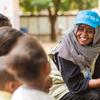 Membro da equipe do Unicef fala com crianças deslocadas em um ponto de encontro em Madani, no centro-leste do Sudão.