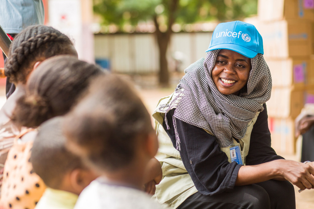 Une employée de l'UNICEF s'entretient avec des enfants déplacés à un point de rassemblement à Madani, dans le centre-est du Soudan.