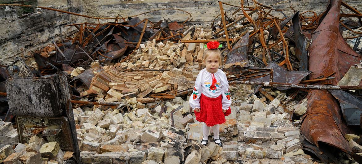 Une jeune fille pose sur les décombres de son école à Horenka, dans la région de Kyïv, en Ukraine.