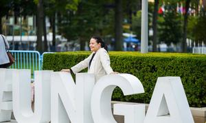 Un delegado posa detrás del letrero de la AGNU fuera de la Asamblea General de las Naciones Unidas.