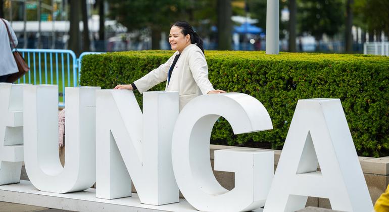 Un delegado posa detrás del letrero de la AGNU fuera de la Asamblea General de las Naciones Unidas.