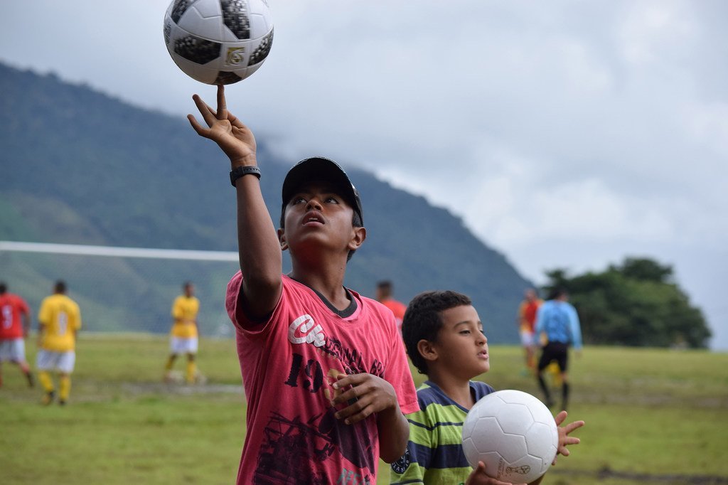 Des enfants regardent d'anciens combattants des FARC-EP, de l'ELN, du groupe paramilitaire AUC, des membres des forces armées colombiennes et des victimes jouer un match amical à Dabeiba, Antioquia.