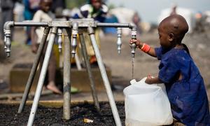 A child fills a jerrycan with safe water at a displaced camp near Goma, in the Democratic Republic of the Congo.
