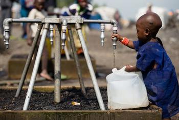 طفل يملأ وعاء بمياه صالحة للشرب في مخيم للنازحين بالقرب من غوما في جمهورية الكونغو الديمقراطية.