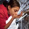 Una niña bebe agua de una toma en su casa en un barrio marginal de El Cairo, Egipto.