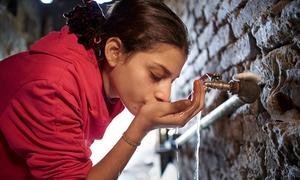 A girl drinks water from a tap in her house in a slum in Cairo, Egypt.