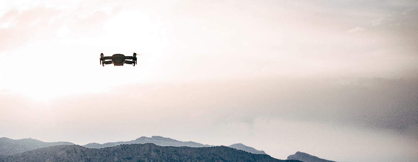 Un drone survole une chaîne de montagnes au crépuscule.