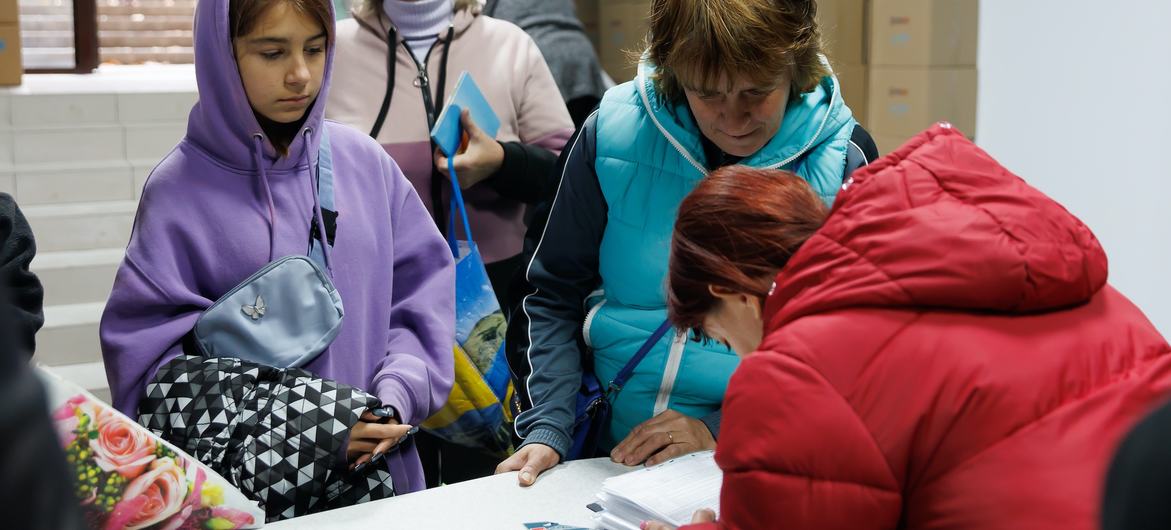 Malgré les difficultés, les femmes dirigent et facilitent les efforts de secours partout dans le monde. Sur cette photo d’archives, une travailleuse humanitaire distribue des vêtements d’hiver aux familles touchées par le conflit en Ukraine.