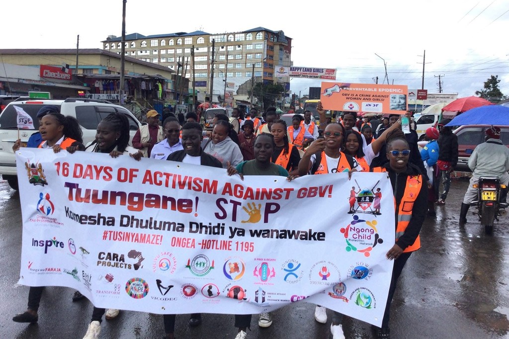 Un groupe de femmes et de militantes kényanes défilent dans une rue de la ville en brandissant une grande banderole pour la campagne « 16 jours d'activisme contre les violences sexistes » menée par FODDAJ.